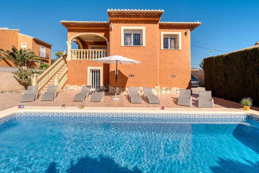 a villa with a swimming pool in front of a house at Villa Casita - PlusHolidays in Calpe