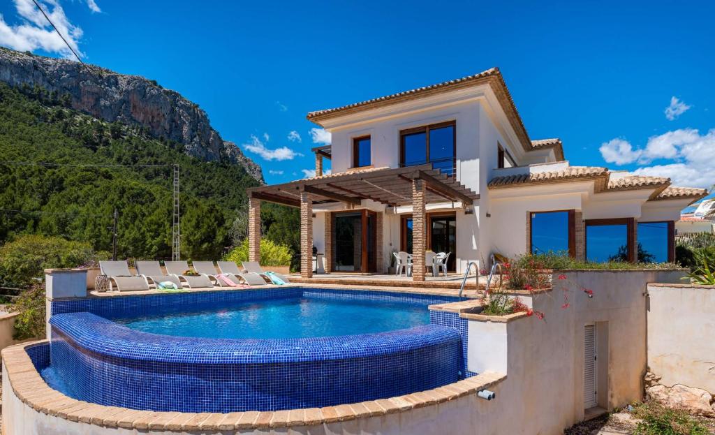 a villa with a swimming pool and a house at Villa Anis - PlusHolidays in Calpe
