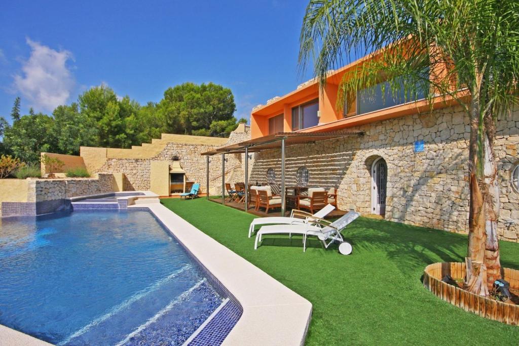 a backyard with a swimming pool and a house at Villa Oasis - Plusholidays in Calpe