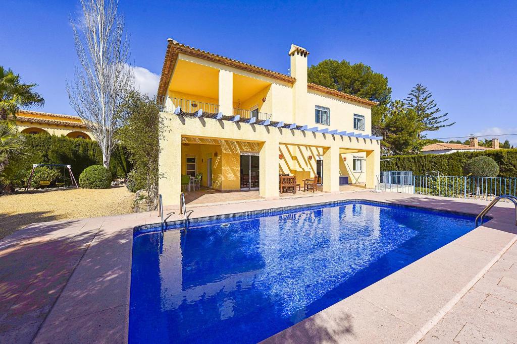 a house with a swimming pool in front of a house at Villa Gio - PlusHolidays in Calpe