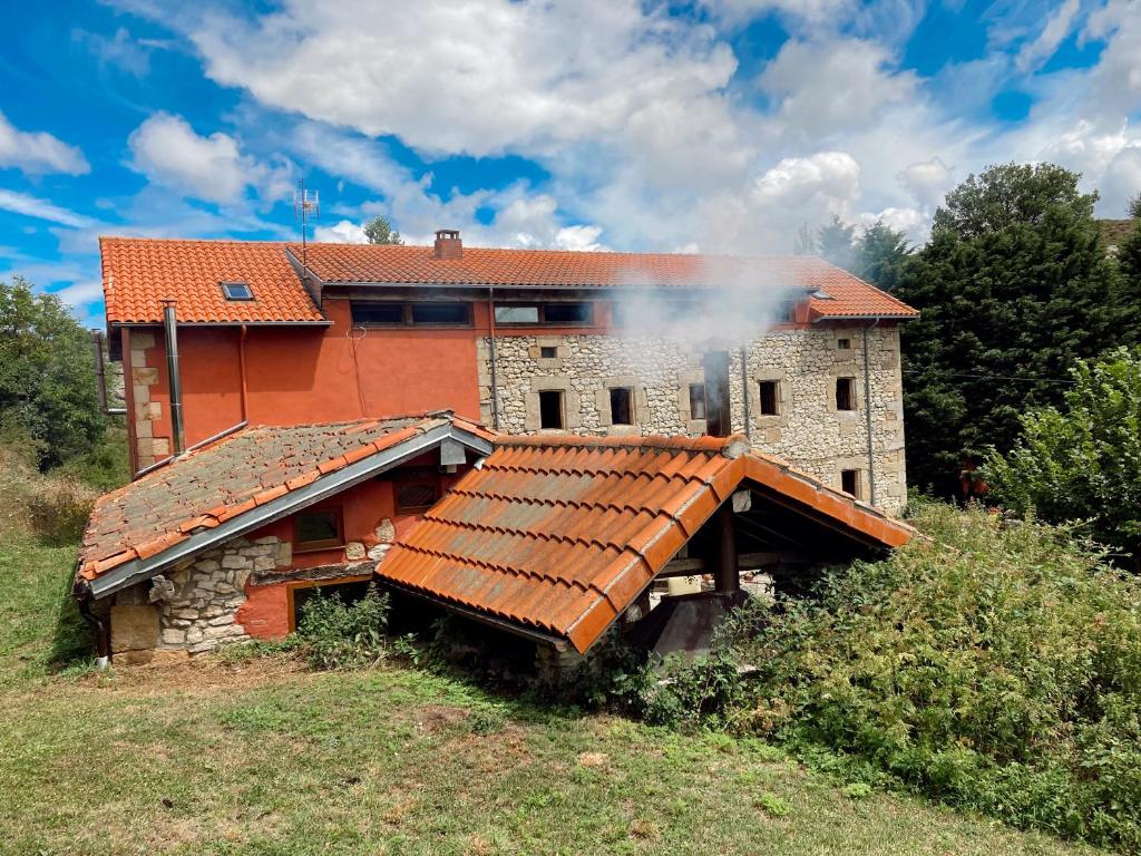 Ein Haus mit einer Rauchwolke. in der Unterkunft Casa Rural Molino de Luna in Soncillo