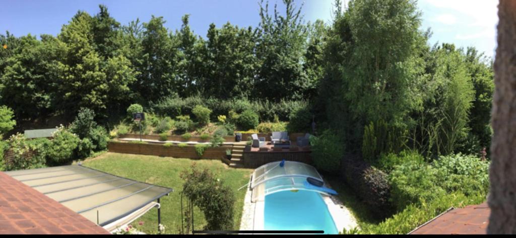 - une vue sur le jardin et la piscine dans l'établissement Une belle chambre au calme avec piscine, à Ormesson-sur-Marne