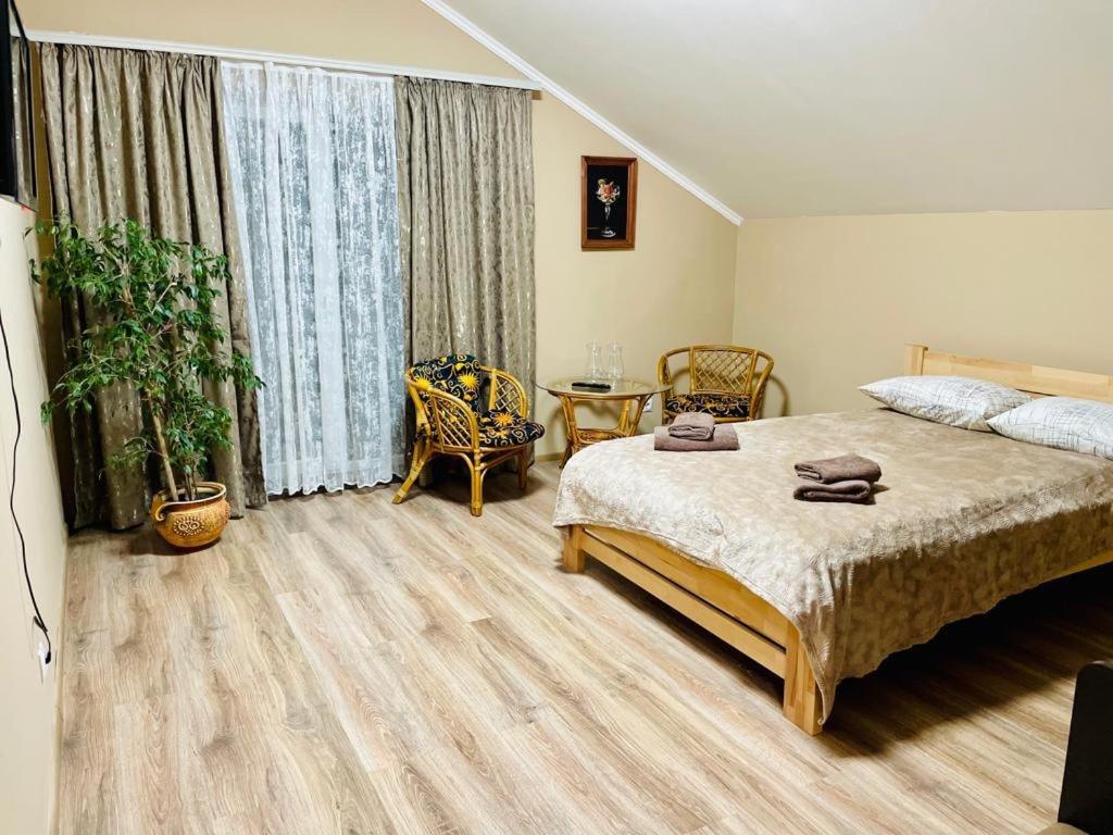 een slaapkamer met een groot bed en een tafel bij Капрі in Mukacheve