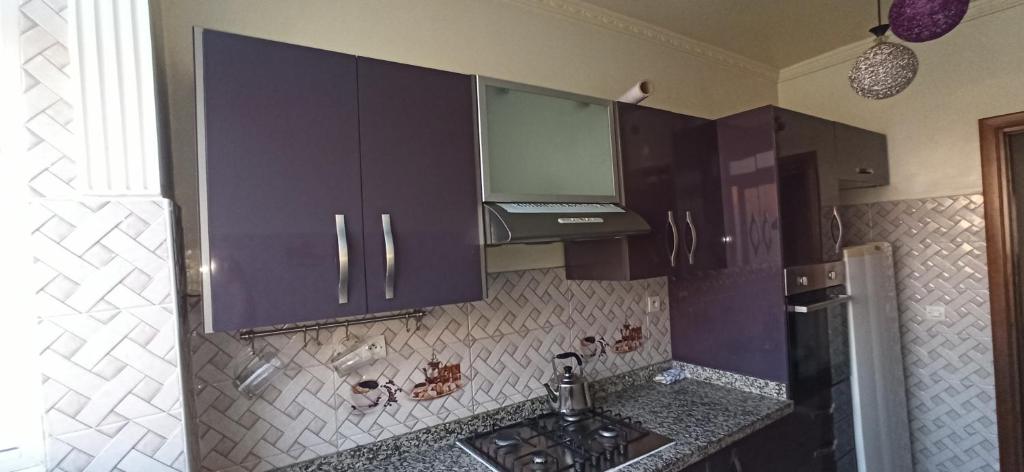 a kitchen with purple cabinets and a sink at Maison de la famille in Casablanca