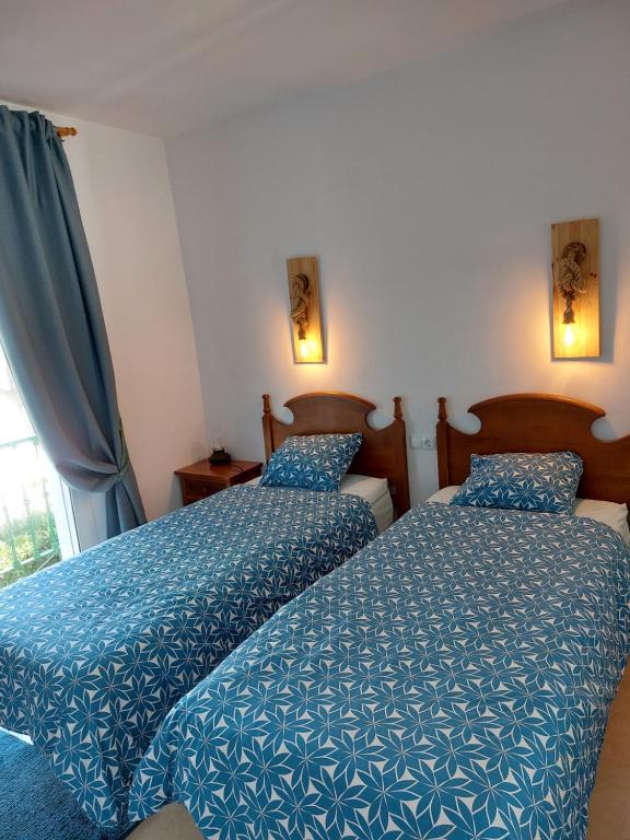 two beds in a hotel room with blue comforter at Carib Playa Marbella apartments in Marbella