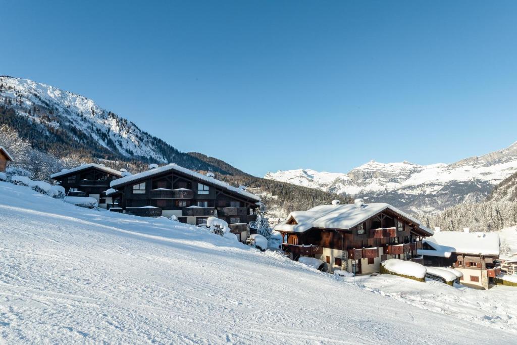 un groupe de bâtiments sur une montagne enneigée dans l'établissement APARTMENT REFUGE DE BELLACHAT - Alpes Travel - Les Houches - Sleeps 4, aux Houches