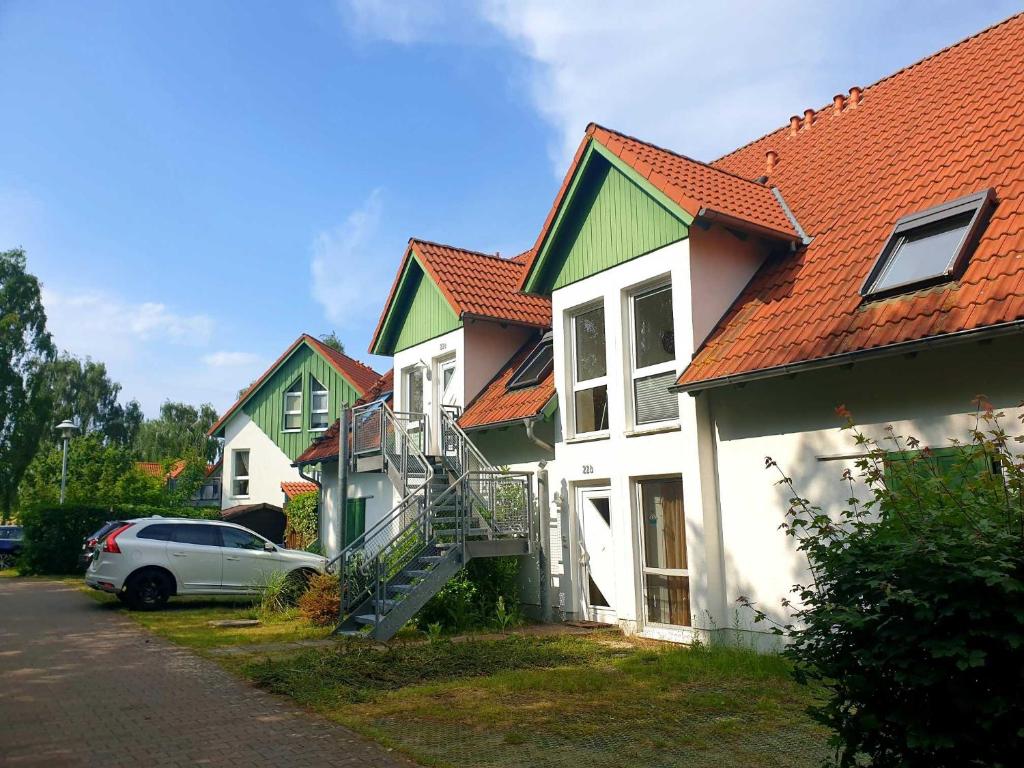 a group of houses with red roofs and a car at Ferienwohnung Strandgold OLIV in Ostseebad Karlshagen