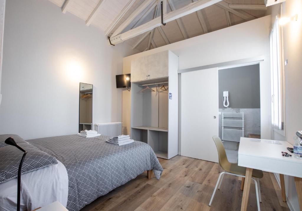 a bedroom with a bed and a desk and a table at Casa Livia in Pordenone
