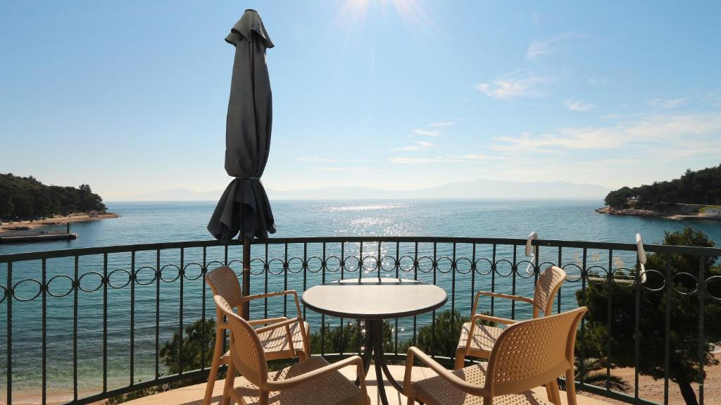 een tafel en stoelen op een balkon met uitzicht op de oceaan bij Apartments on the beach-Drvenik in Drvenik