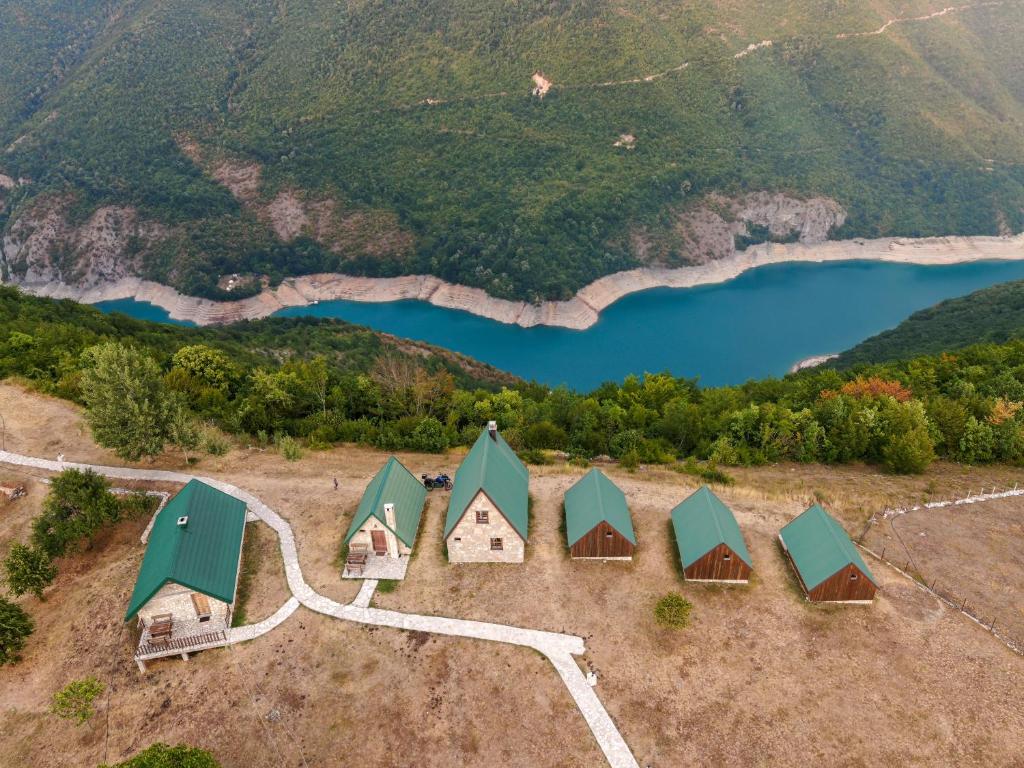 una vista aérea de un grupo de cabañas junto a un lago en Etno selo Izlazak en Rudinice