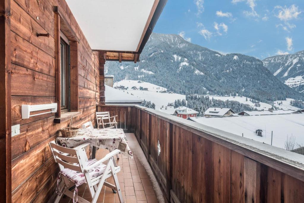 a balcony with a table and chairs and mountains at Casa Rustica App Seceda in Ortisei