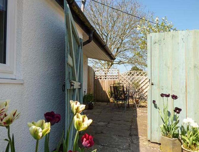 een tuin met bloemen en een wit hek bij Rectory Cottage in Abergavenny