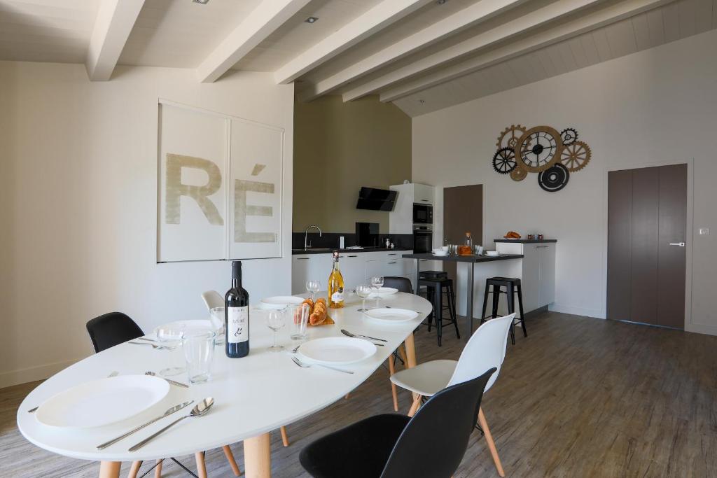 een eetkamer met een witte tafel en stoelen bij Appartement lumineux pour six personnes in Le Bois-Plage-en-Ré