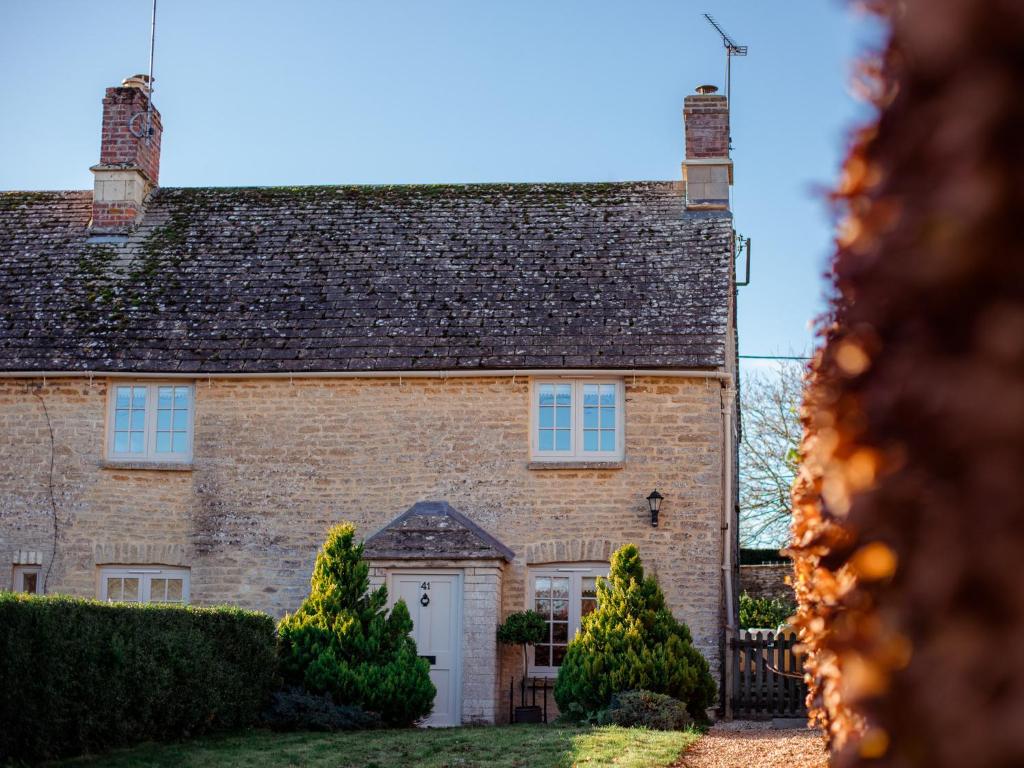 een groot bakstenen huis met een witte deur bij Laurel Cottage in Cirencester