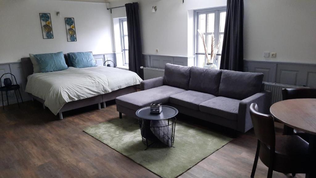 een woonkamer met een bank en een bed bij B&B D'n Optie in Druten