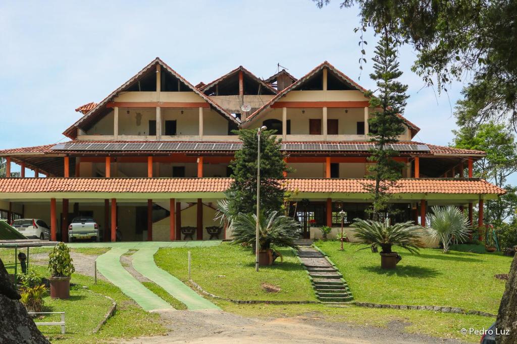 a large building with trees in front of it at Hotel Chalés Terra Nova in Itatiaia