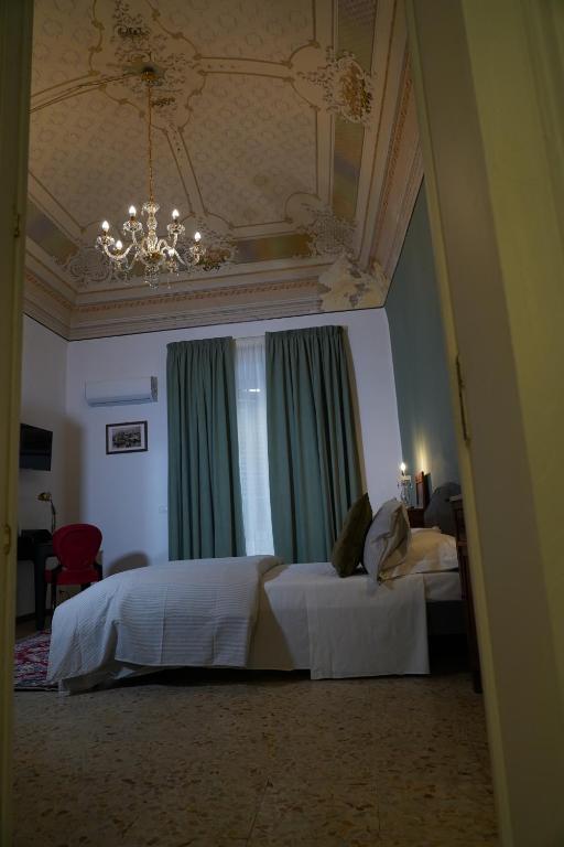 a bedroom with two beds and a chandelier at DS Apartments in Catania