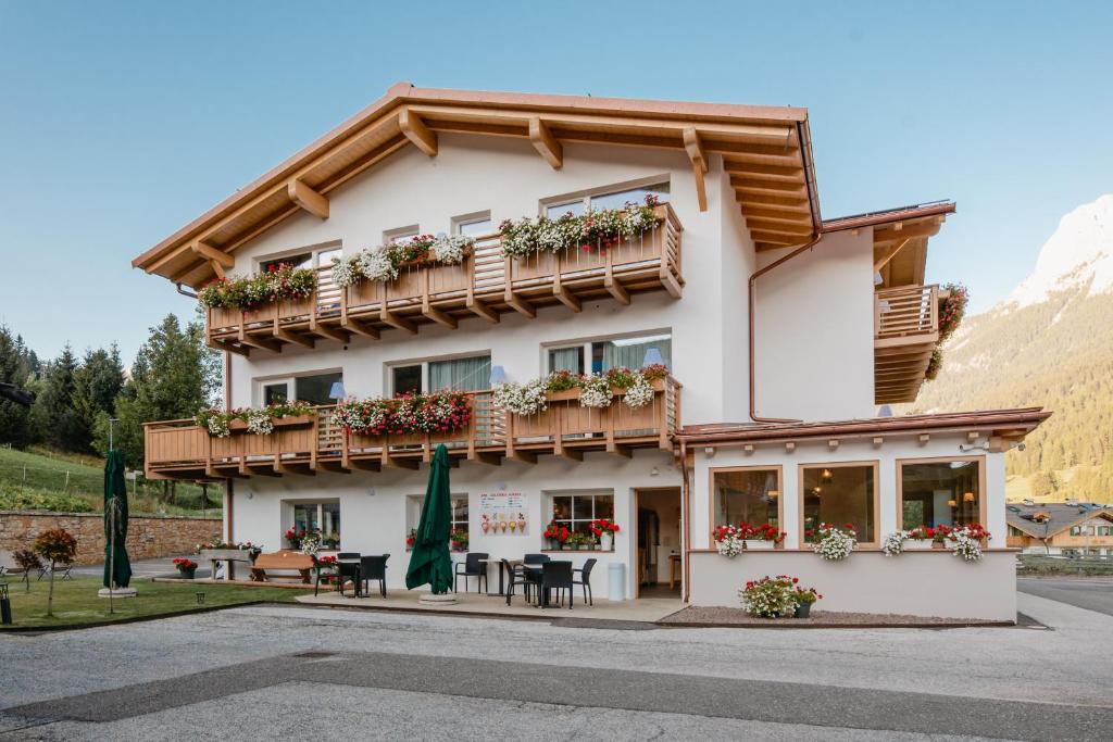 un hotel en las montañas con mesas y sillas en Garnì Aurora Bed and Breakfast en Soraga