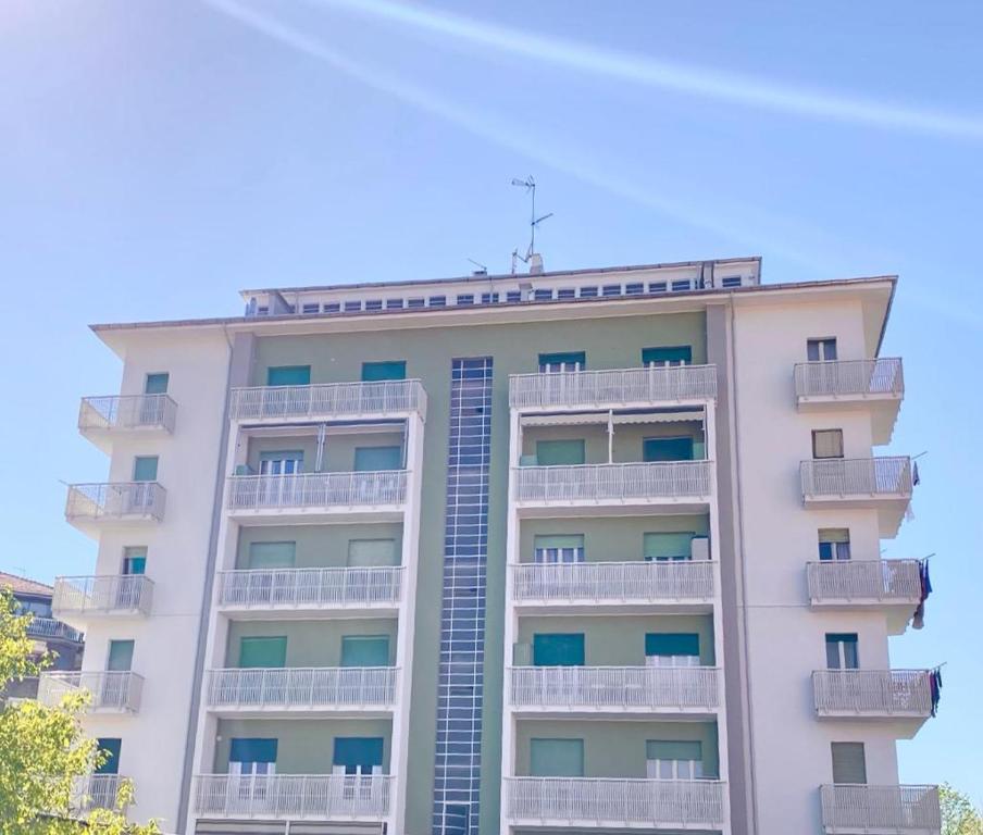 a tall white building with balconies on it at HH Hermoso Housing VIA PAIETTA in Valenza