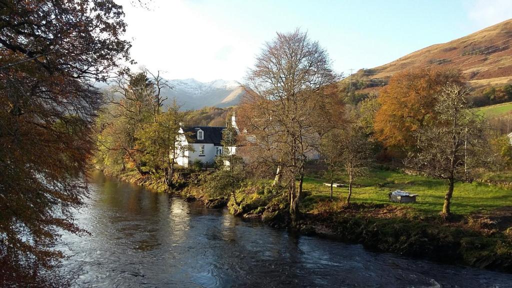 a river with a house on the side of it at Orchy Bank House in Dalmally