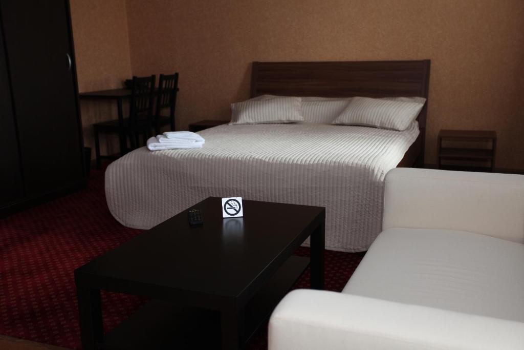 a hotel room with two beds and a table and chairs at Troya Hotel in Rudny