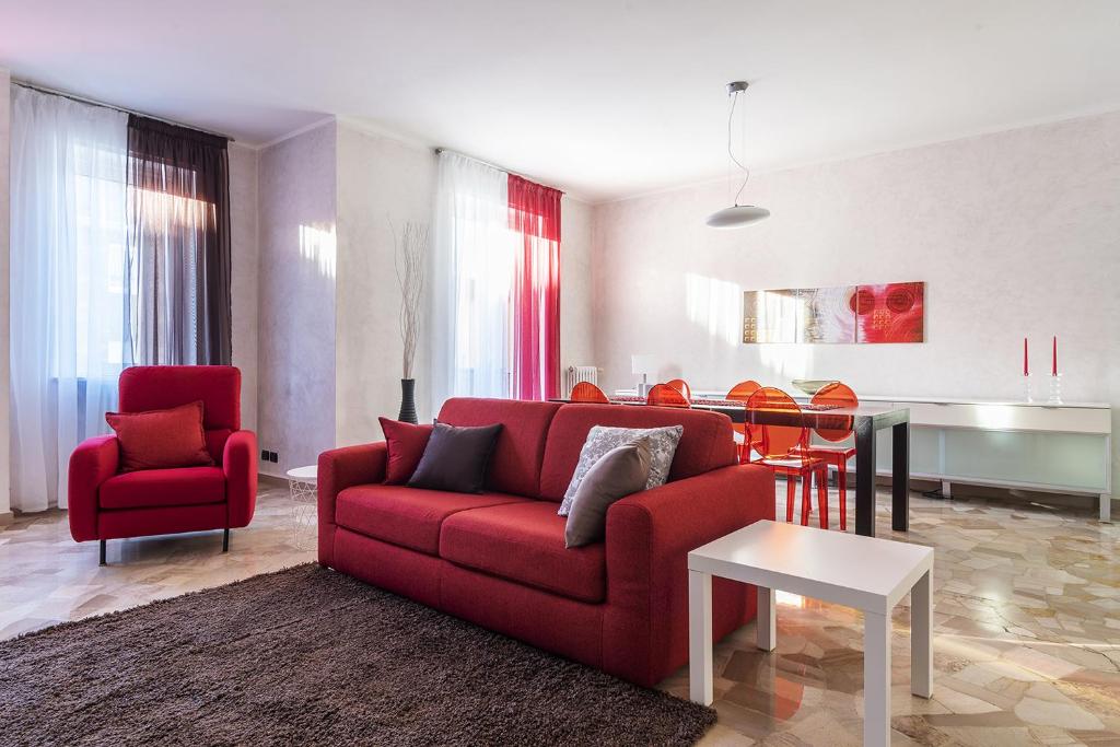 uma sala de estar com um sofá vermelho e uma mesa em La casa di Cri sul Naviglio em Milão