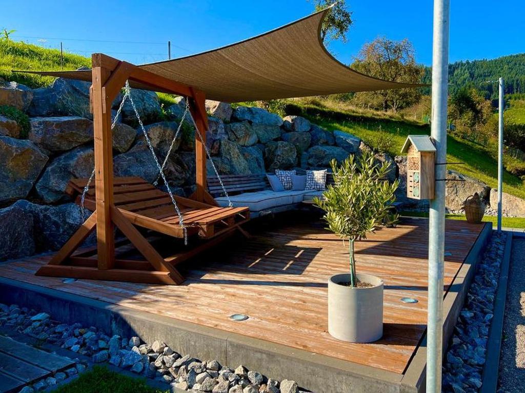 una terraza de madera con hamaca y una tienda de campaña en Black Forest Appartement - Brandenkopfblick, en Zell am Harmersbach