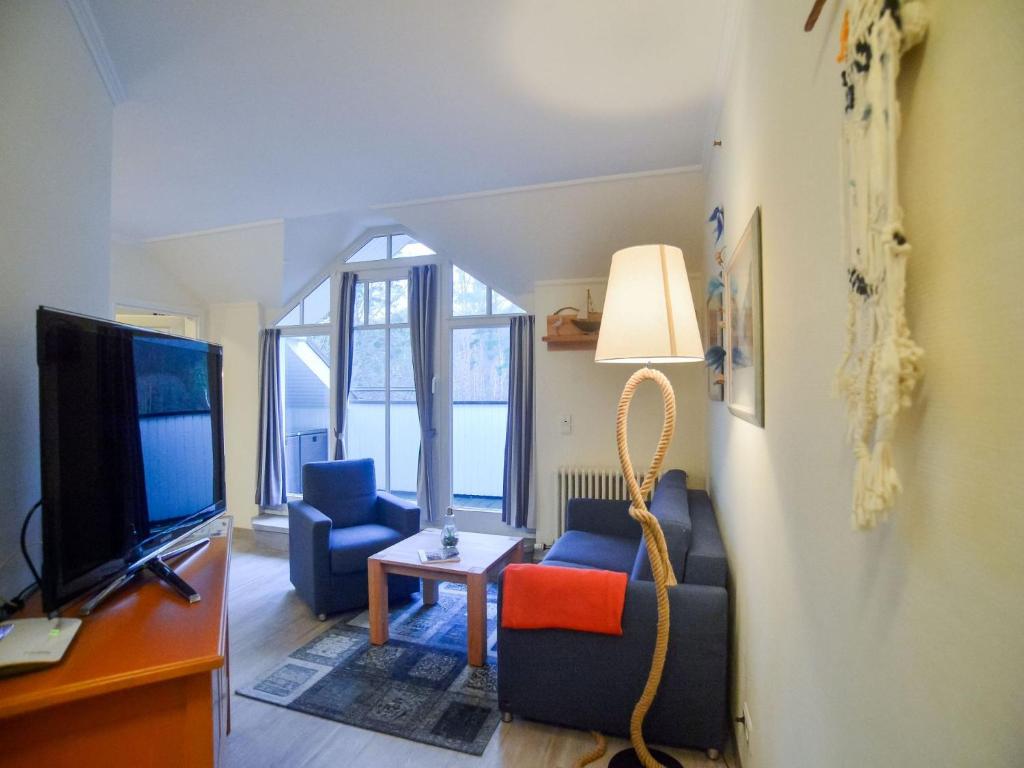 ein Wohnzimmer mit 2 Stühlen und einem TV in der Unterkunft Dünenpark Binz - Komfort Ferienwohnung mit 1 Schlafzimmer und Balkon im Dachgeschoss 282 in Binz