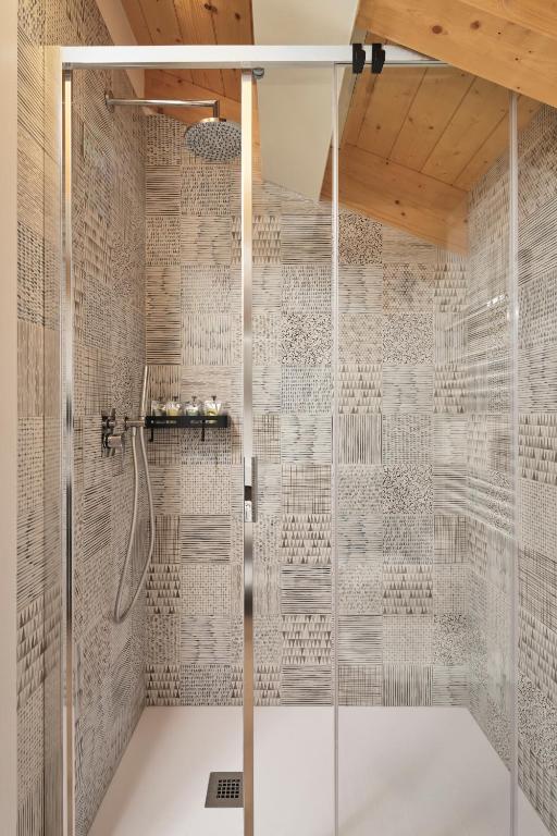 a shower with a glass door in a bathroom at Crocevia - Locanda carsica contemporanea in Trieste