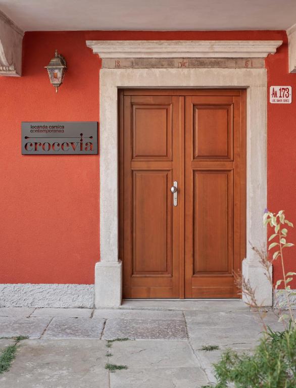 a wooden door on the side of a building at Crocevia - Locanda carsica contemporanea in Trieste