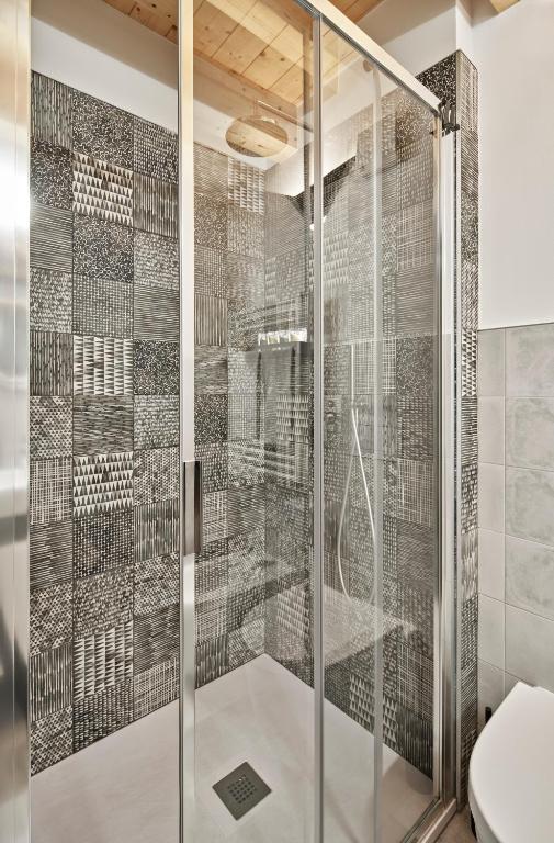 a glass shower with a toilet in a bathroom at Crocevia - Locanda carsica contemporanea in Trieste
