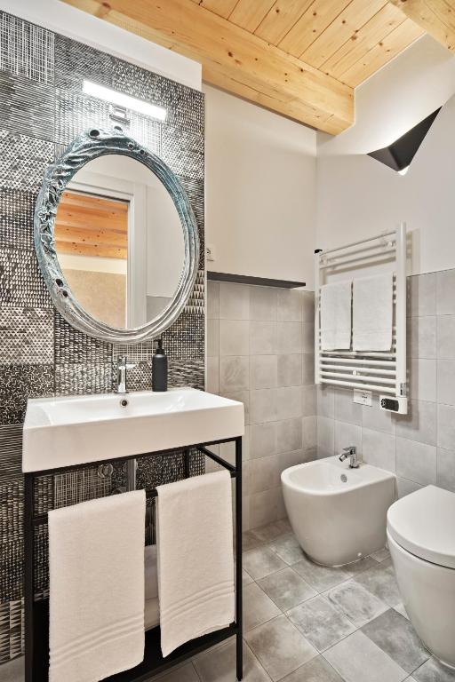 a bathroom with a sink and a toilet and a mirror at Crocevia - Locanda carsica contemporanea in Trieste
