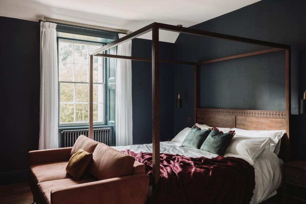 a bedroom with a canopy bed and a couch at Killiecrankie House in Pitlochry