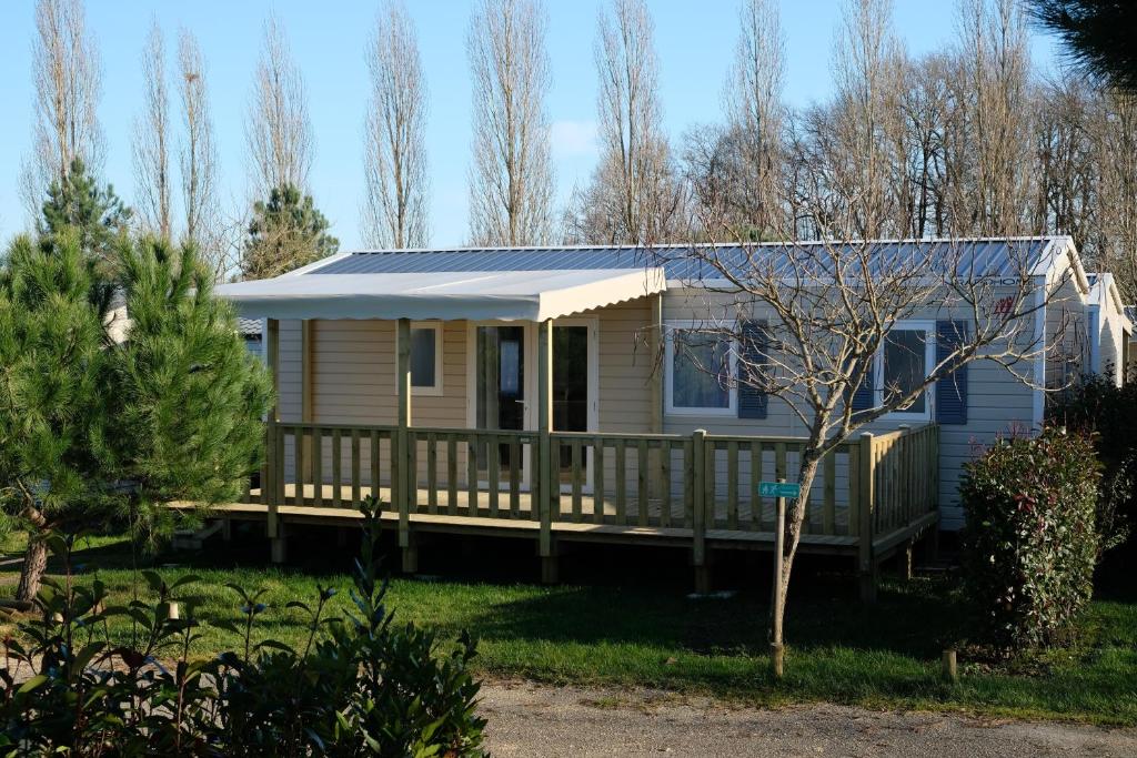 a house with a porch with a solar roof at Camping les Lacs d'Armagnac in Bretagne-dʼArmagnac