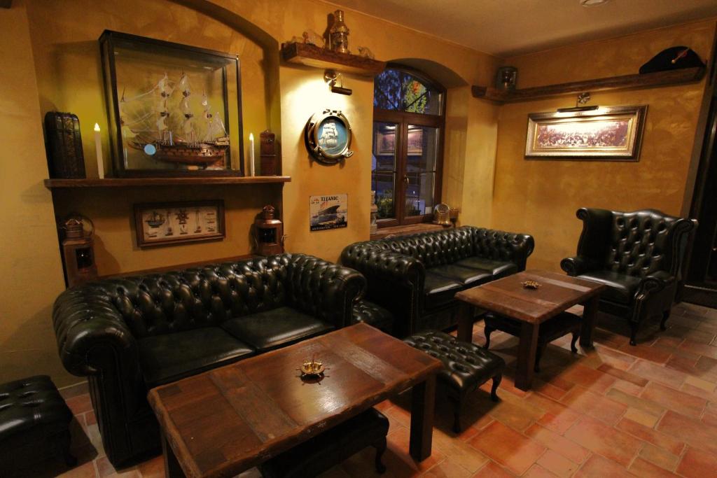 a living room with leather furniture and a table at Hotel Starý Mlýn in Mlýnec