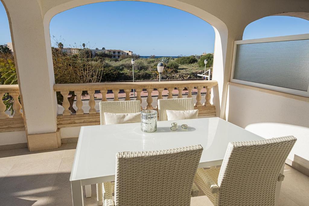 a white table and chairs on a balcony at Moderne Ferienwohnung Primavera in Colonia Sant Jordi