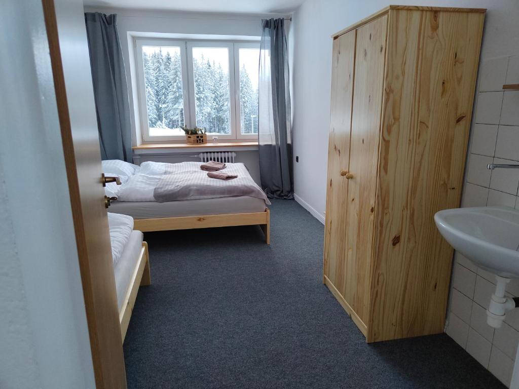 a bedroom with a bed and a sink and a window at Chata - Dom Horskej služby Jasna in Demanovska Dolina