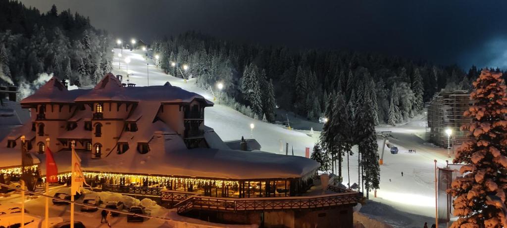 a large building with snow on top of it at night at Snježna Vila in Jahorina