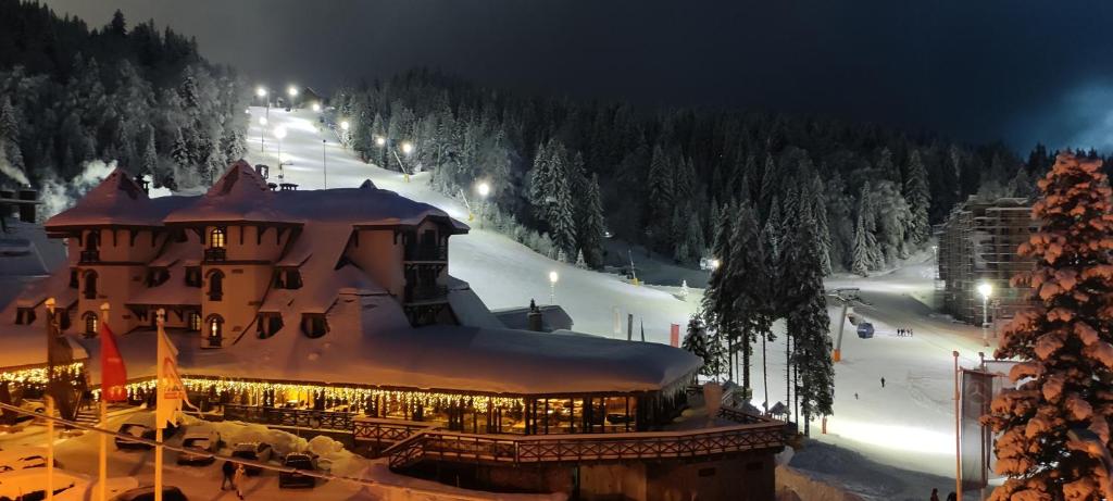a large building with snow on top of it at night at Snježna Vila in Jahorina