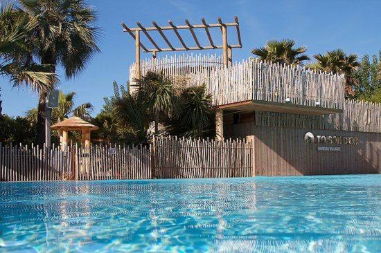 a fence next to a swimming pool with a fenceasteryasteryasteryasteryasteryastery at Mobilhome St Tropez 5H02 in Saint-Tropez