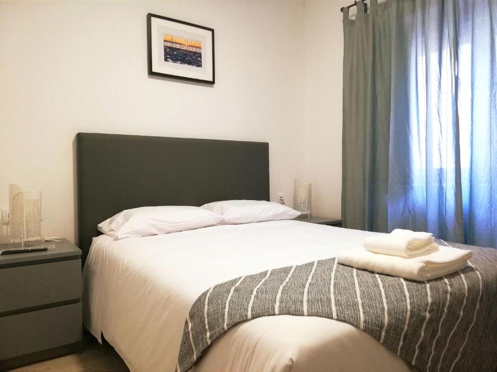 a bedroom with a bed with two towels on it at Cascais Bela House in Cascais