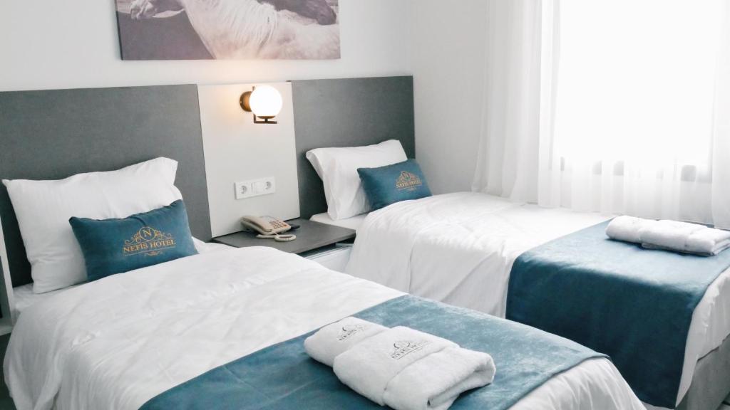 Postel nebo postele na pokoji v ubytování Nefis Hotel City