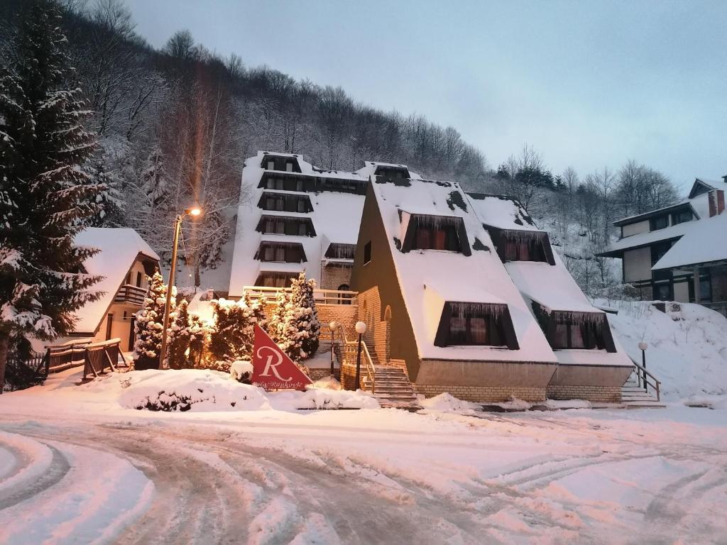 a building covered in snow on a snow covered street at Guest House Villa Rankovic in Brzeće