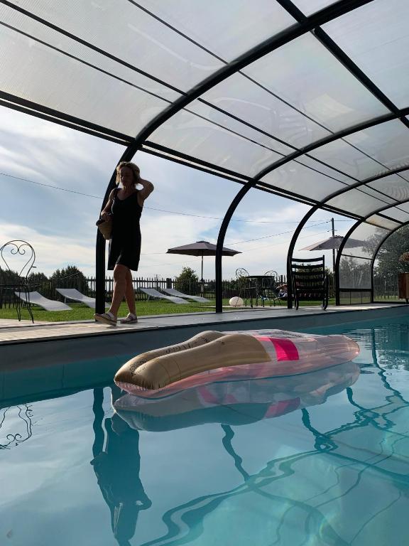 a woman walking next to a swimming pool at Les Chambres de Ribeaufontaine in Dorengt