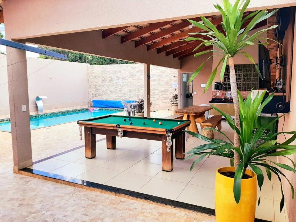 a pool table in a living room with a swimming pool at ESPAÇO FONDER in Caldas Novas
