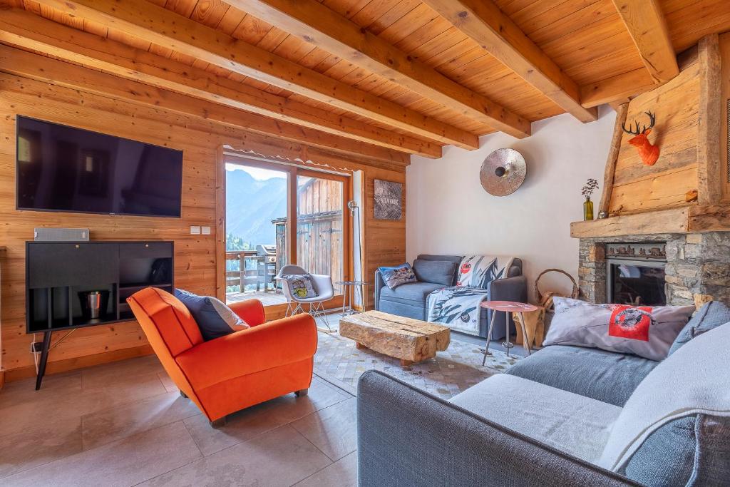 a living room with couches and a tv and a fireplace at Chalet Solize - Terrasse avec superbe vue - Sauna in Champagny-en-Vanoise