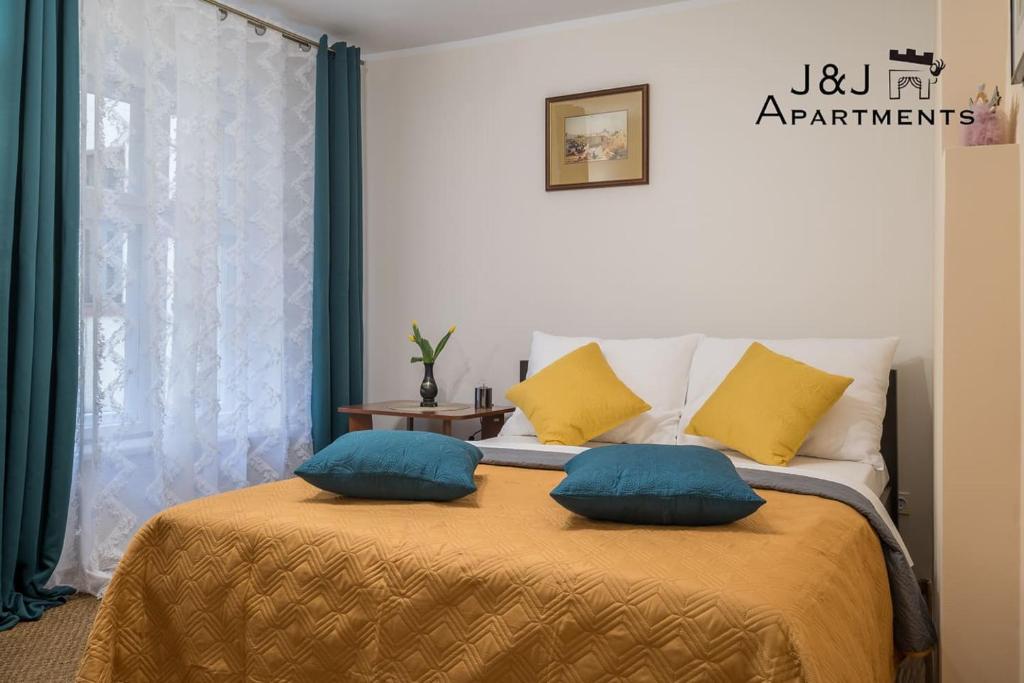 a bedroom with a bed with two pillows on it at J&J Apartments, Szeroka 25 Apartament 13 in Toruń