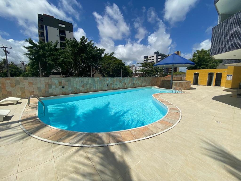 una gran piscina azul con una pared de ladrillo en Flat - Victory Intermares en Cabedelo