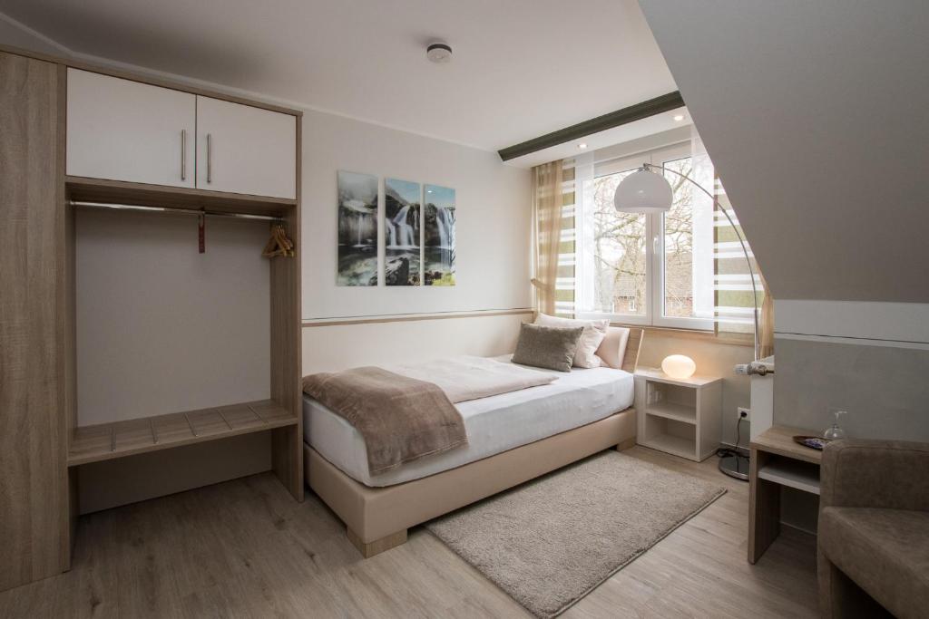 a small bedroom with a bed and a window at Landhotel Zum Hasen Hein in Hamminkeln