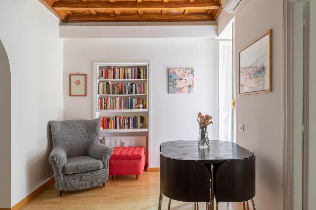 salon ze stołem, krzesłem i półką na książki w obiekcie iFlat Via del Corso Elegant Apartment w Rzymie